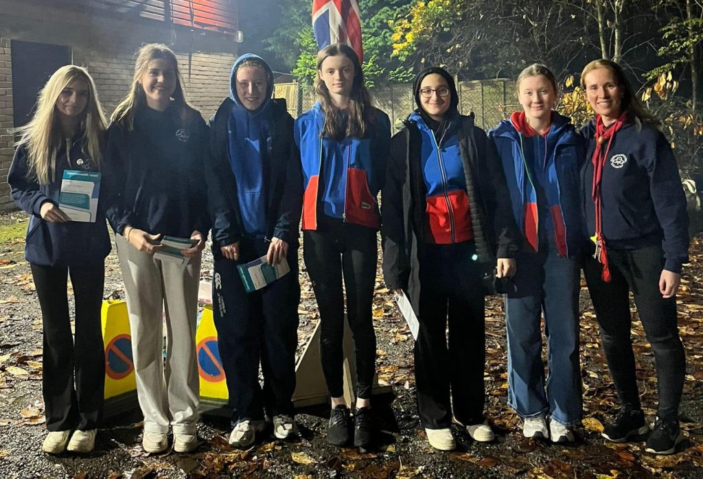 The Guides, pictured with unit leader Victoria Beattie, received their Commonwealth Awards. They are outside in the dark.