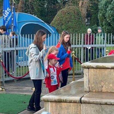 Vale of Leven Remembrance service - a Guide, Brownie, Rainbow and Ranger stand in front of the war memorial while saluting