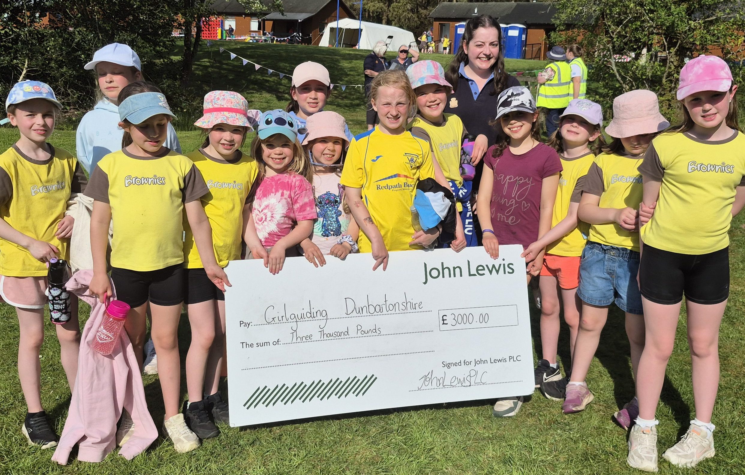 2nd Bearsden Brownies hold up a giant cheque from John Lewis